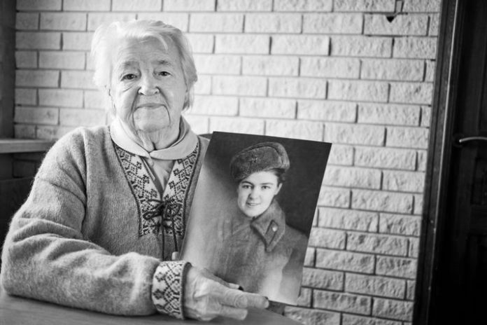 Мария Митрофанова со своей фотографией времен Великой Отечественной войны // Источник: Visir.is/Anton Brink