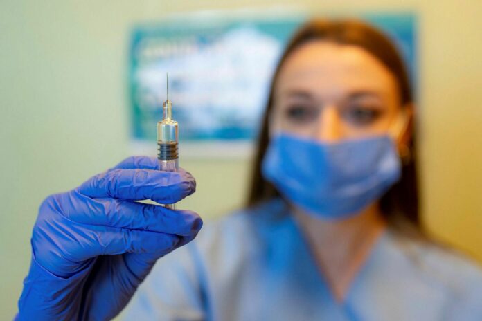 Работник здравоохранения со шприцем с вакциной. Источник mbl.is - AFP